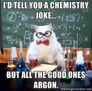 This image of “Chemistry Cat,” a popular meme, depicts an all-white cat, wearing black-rimmed glasses and a red bow tie, seated in a chemistry laboratory. The cat is surrounded by beakers and flasks filled with blue, green, yellow, and red fluids. The chalkboard in the background displays silly equations involving mice, milk, and cheese as the variables. The text on the image reads, in all caps, “I’d tell you a chemistry joke… But all the good ones Argon.” 