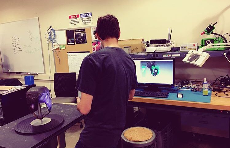 Student using Artec 3D scanner in engineering lab to scan football helmet from Georgia Tech Archives