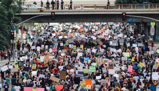 A large protest passes under an underpass in Los Angeles.