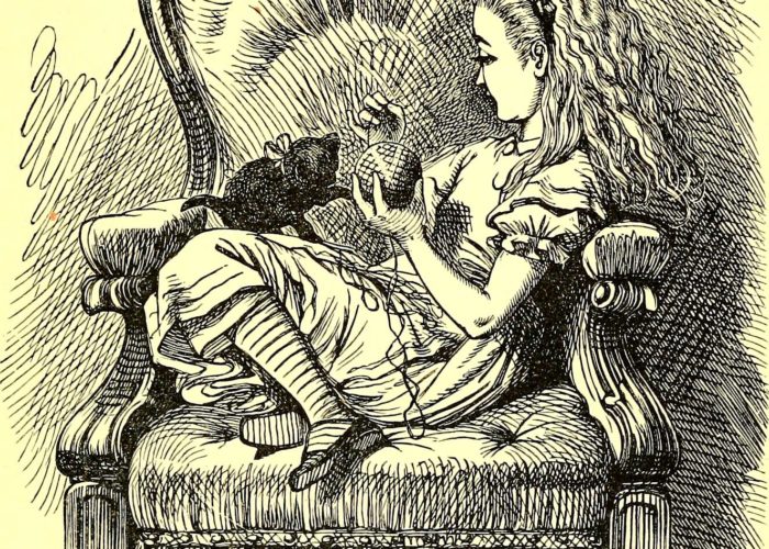 Alice in Wonderland sitting in a chair playing with her kitten and a ball of yarn.