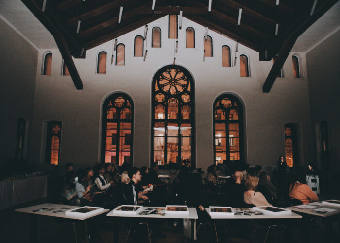 Conference attendees are pictured from the side, under dramatic Russian Orthodox church windows.