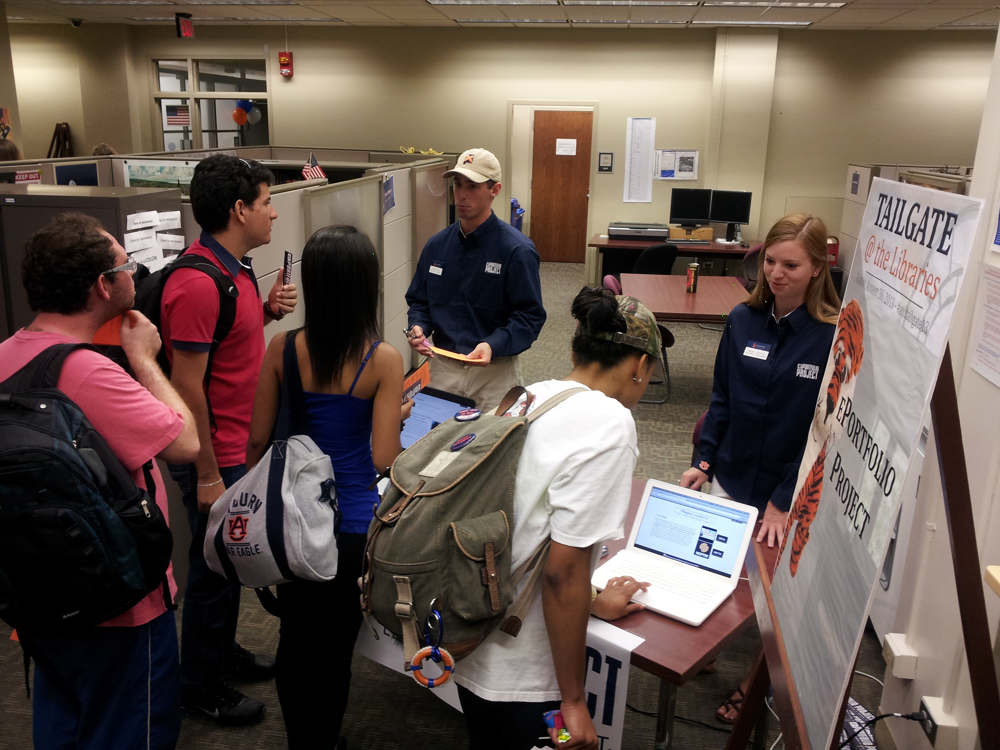 ePortfolio student ambassadors talking to other students next to an advertising poster